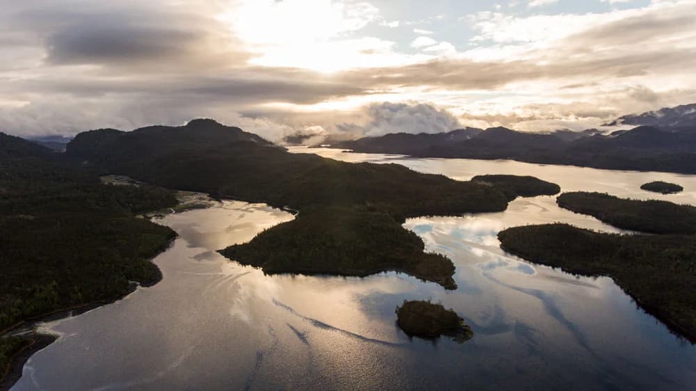 Vista aérea de canales e islas boscosas en Aysén al atardecer